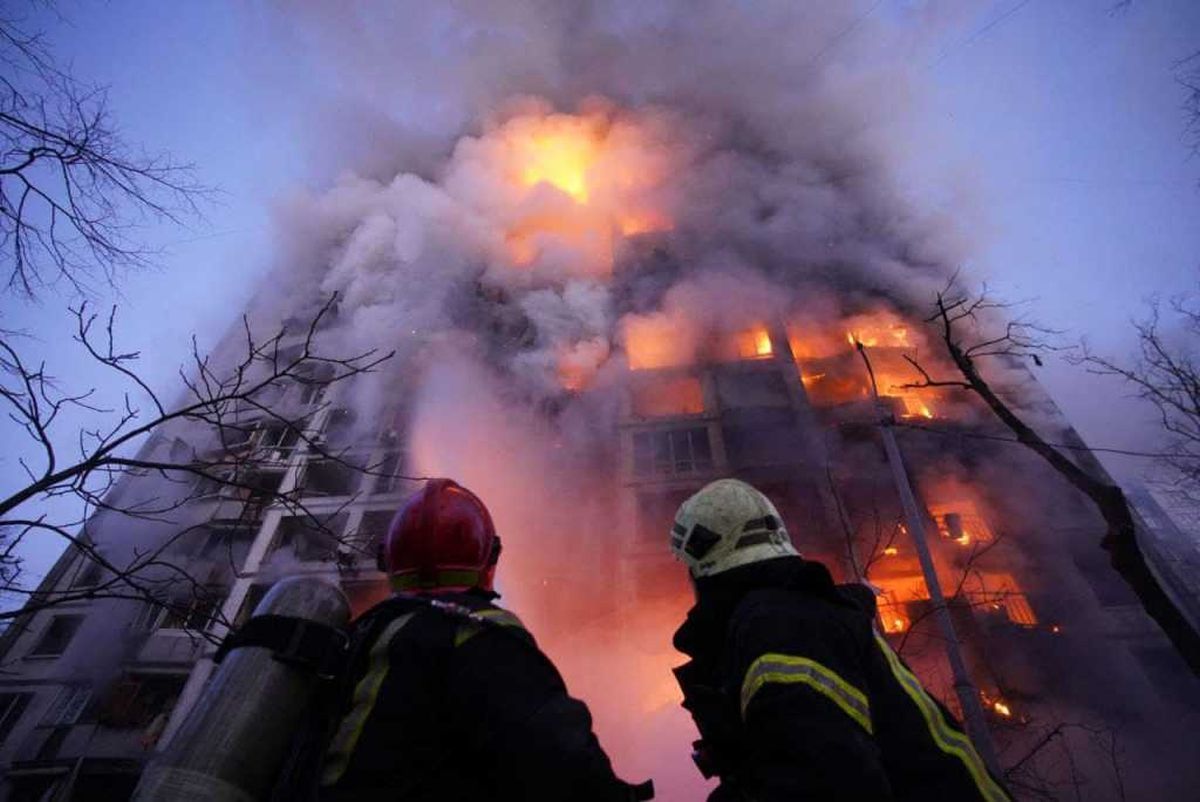Bomberos ucranianos ante un edificio incendiado luego de un bombardeo ruso en la ciudad de Karvik.