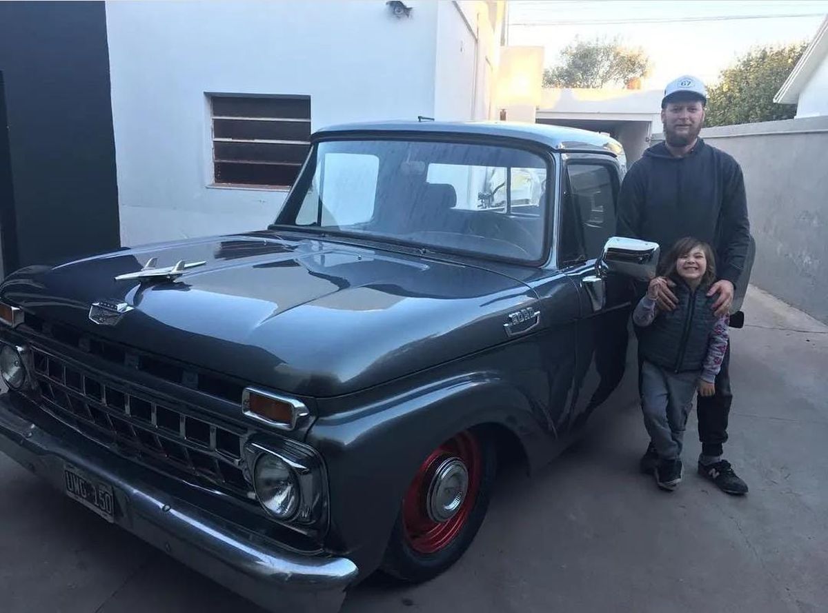 Martín junto a uno de sus hijos y una camioneta Ford del año 1962 que restauró para un cliente. 