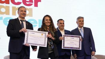 Alicia Eandi, la directora del centro educativo Domingo F. Sarmiento, recibe el premio en manos del ministro de Educación Horacio Ferreyra.