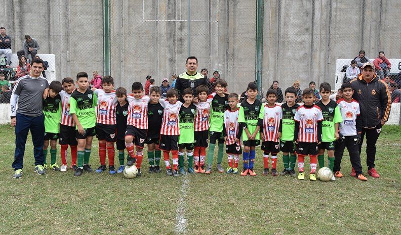 Los jugadores de la categoría 2010 de Asociación Atlética Banda Norte B y Sportivo Municipal junto a sus directores técnicos y el árbitro del cotejo, en el mediodía del sábado en el miniestado del Verde.
