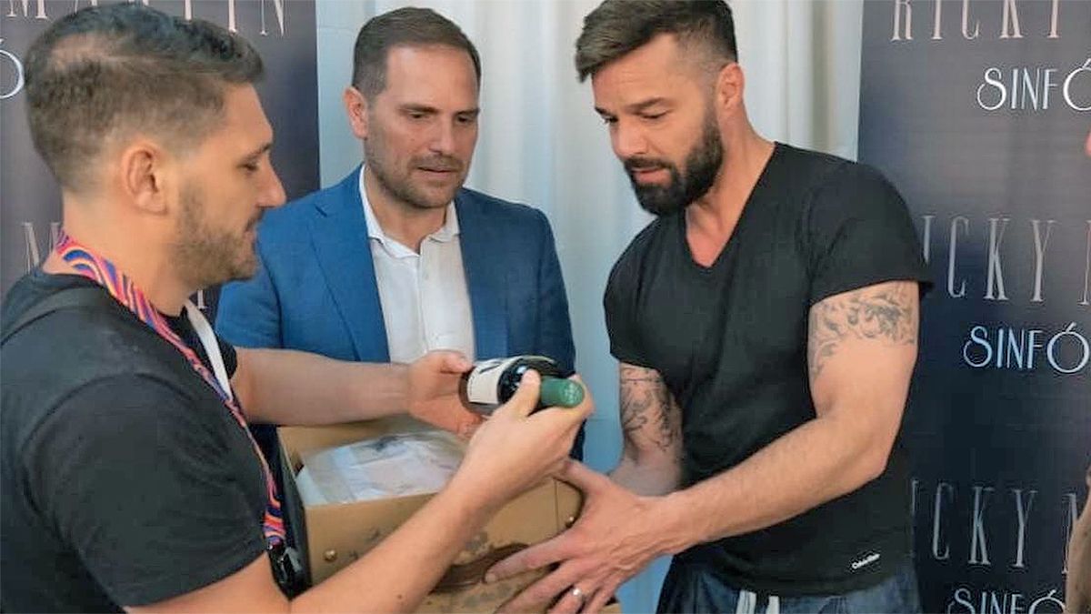Martín Enricci le entrega a Ricky Martin un vino con su arte plasmado en la etiqueta y una pintura. 