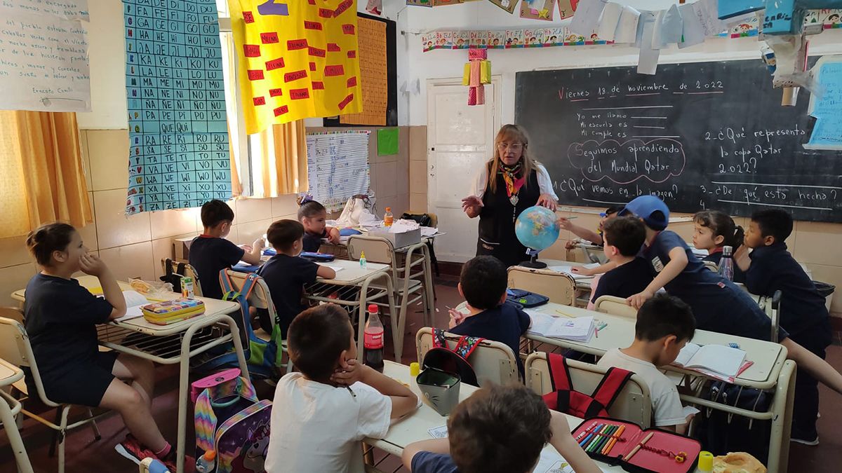 La señorita Eva junto a sus alumnos. Les explica en un globo terráqueo donde se ubica Qatar.