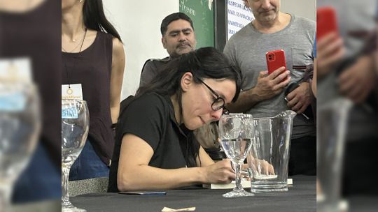 La historiadora Julia Rosemberg firmando libros entre los asistentes de la charla en la UNRC