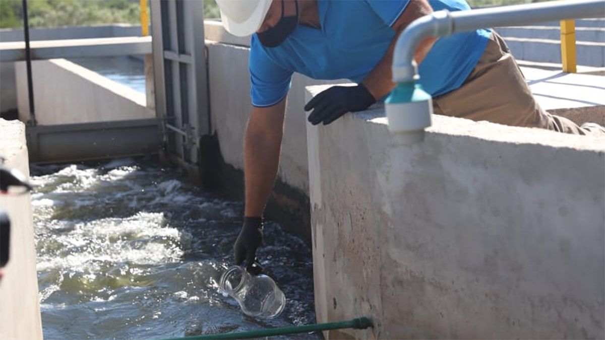 El momento en que un operario toma una muestra de agua procesada en la flamante planta cloacal.
