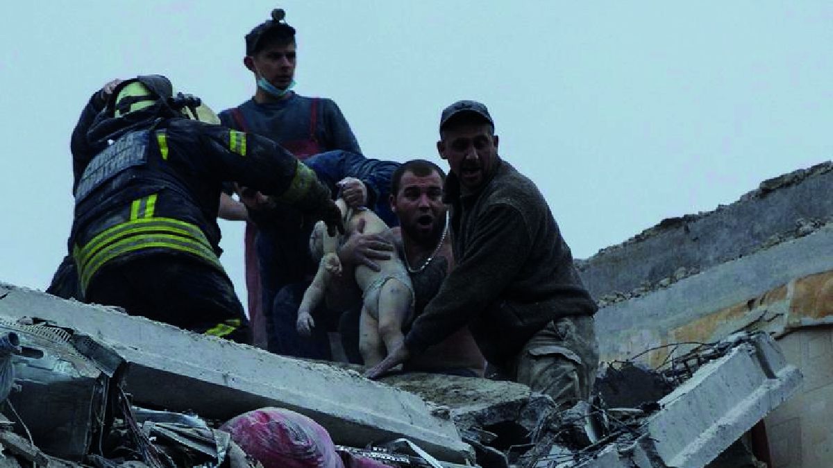 Ucrania: voluntarios y trabajadores de servicios de emergencia rescatana un bebé de un edificio de departamentos dañado por un ataque militar ruso en Sloviansk